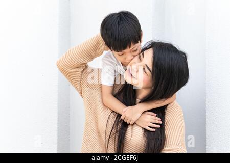 Mutter und Kind umarmten sich und küssten sich gegenseitig die Wangen. Asiatische Familie Mutter und Kind umarmen und duftend, Wangen zusammen, niedlich und warm. Stockfoto