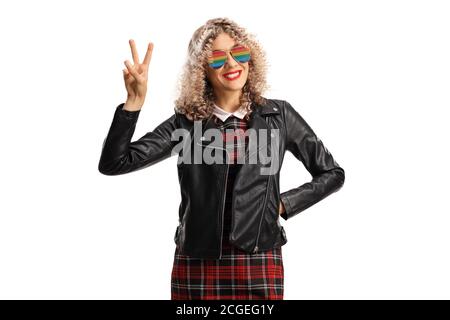 Junge Frau in einer Lederjacke trägt Regenbogensonnenbrille und Gestikuliertes Friedenszeichen isoliert auf weißem Hintergrund Stockfoto