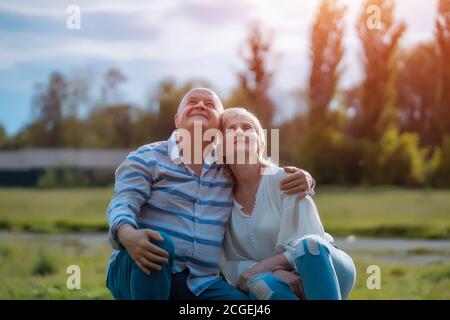 Glückliches Seniorenpaar aus und Umarmung und Gespräch im Park An sonnigen Tagen Stockfoto