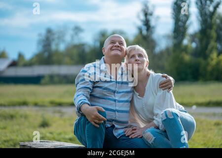 Glückliches Seniorenpaar aus und Umarmung und Gespräch im Park An sonnigen Tagen Stockfoto