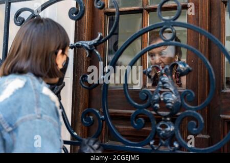 Stadt Buenos Aires, Stadt Buenos Aires, Argentinien. September 2020. INT. WorldNews. September 2020. Stadt Buenos Aires, Argentinien.- Elsa Giudici de Magdaleno besucht von ihrer Enkeltochter in der Stadt Buenos Aires, Argentinien, eine Altersresidenz inmitten der neuen Coronavirus-Pandemie.Sie sehen sich durch das Fenster, sprechen aber telefonisch. Quelle: Julieta Ferrario/ZUMA Wire/Alamy Live News Stockfoto