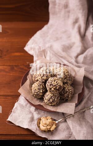 Kakaobälle, Schokolade Trüffel Kuchen an Bord auf Holz Hintergrund Cashewnüsse bestreut Stockfoto