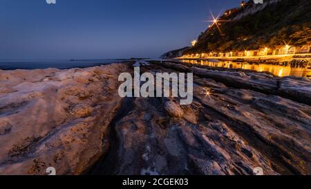 Passetto Strand mit typischen Fischerhöhlen in Ancona - Marken - Italien, bei Sonnenuntergang Stockfoto