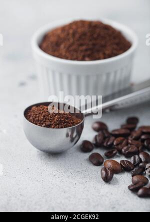 Kaffeepulver in weißer Keramikschale mit Stahlkaffee soop auf hellem Tischhintergrund. Makro Stockfoto