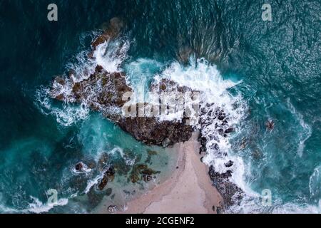 Wellen, die in die Felsen des Plaka-Strandes auf der Halbinsel Pelion, Griechenland, plätschern. Foto mit Drohne aufgenommen. Stockfoto