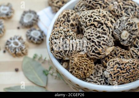 Frisch geerntete frühlingsessbare Morchelpilze in einer Keramikschale. Nahaufnahme, selektiver Fokus. Stockfoto