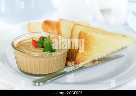 Hausgemachte Leberpastete mit knusprigen Brotscheiben. Nahaufnahme, selektiver Fokus Stockfoto