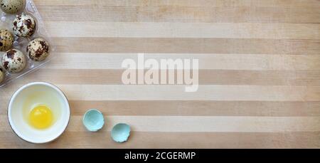 Wachteleier beim Kochen auf einem gestreiften Holzschneidebrett Nahaufnahme mit Kopierraum, Draufsicht. Gesunde Ernährung Konzept. Stockfoto