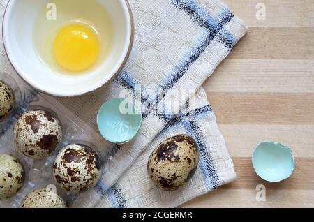 Wachtel Eier in den Prozess des Kochens auf einem hölzernen Schneidebrett mit einem Küchentuch close-up, Draufsicht. Gesunde Ernährung Konzept. Stockfoto