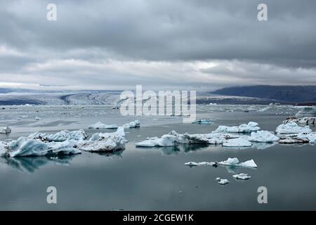 Von der Breiðamerkurjökull-Drift in der Jökulsárlón-Gletscherlagune, Südisland, wurden Eisbrocken abgebrochen. Das Sonnenlicht wird im Spiegel wie ein See reflektiert. Stockfoto