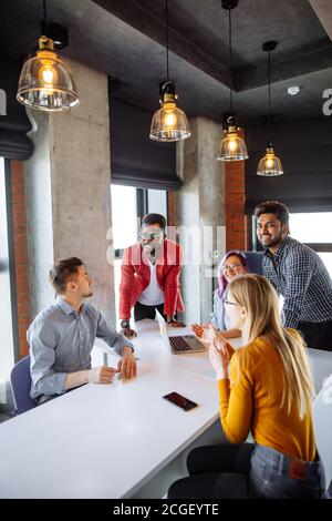 Diverse multiethnische Gruppe junger Geschäftsleute in Office Sitzungssaal versammeln um weißer Tisch, diskutieren ihre Geschäftsstrategie und Sh Stockfoto