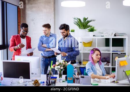 Startup-Unternehmen multiethnischen Team diskutieren neue Business-Plan in modernen hellen Büroinnenraum Brainstorming, arbeiten auf Laptop und Tablet-Computer Stockfoto