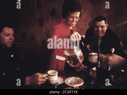 Kellnerin gießt Kaffee für Polizisten in einem Café in Gewehr, Colorado 1973 Stockfoto