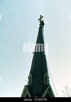 Arbeiter auf dem Kirchturm von St. Paul's der evangelischen lutherischen Kirche in New Ulm, Minnesota Ca. 1975 Stockfoto