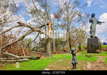 Umgestürzte Bäume und Trümmer vom Hurrikan Laura umgeben die Millennium Jesus Statue auf dem Bilbo Friedhof, 9. September 2020, in Lake Charles, Louisiana. Stockfoto