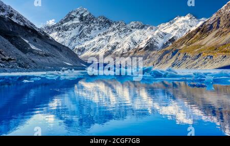 Hooker Gletscher schmelzen mit schneebedeckten Mount Cook in der Die Distanz spiegelt sich im See und einem schönen klaren Blau Himmel Stockfoto