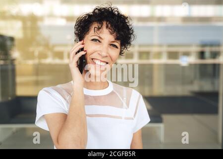 Nahaufnahme Porträt von lächelnden reifen Frau im Gespräch auf smart Telefon in der Stadt Stockfoto