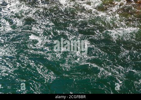 Nahaufnahme von fließendem grünem, sonnendurchfluteten Wildwasser Stockfoto