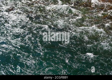 Nahaufnahme von fließendem smaragdgrünem, sonnendurchfluteten Wildwasser Stockfoto