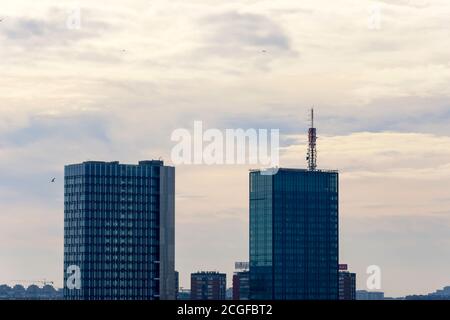 Nahaufnahme von zwei Wolkenkratzern in Belgrad bei Sonnenuntergang An einem bewölkten Tag Stockfoto