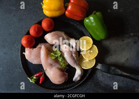 Rohes Fleisch mit frischem Gemüse auf einer schwarzen Pfanne Stockfoto