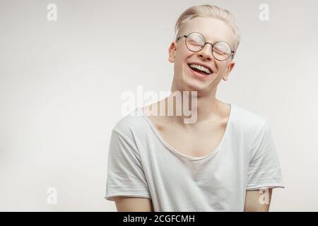 Happy blonde Mann in Spactacles mit ungewöhnlich schönen Auftritt lächelnd In die Kamera mit zufrieden träumenden Ausdruck glücklich mit kommen holida Stockfoto