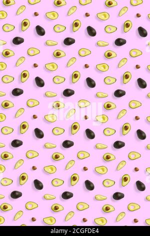 Avocado. Hintergrund aus isolierten Avocado Stücke auf rosa Hintergrund. Flache Laie aus frischen reifen Avocados und Avacadostücken. Stockfoto