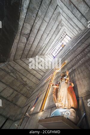 Blick auf den Kamin-ähnlichen Turm, vom Altar, Kruzifix und Statue von Jesus, zu einem hohen Fenster Licht, atemberaubende brutalistischen kommunistischen Ära Design, com Stockfoto