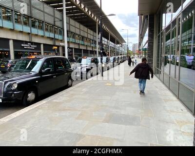 Reihe von schwarzen Taxis in Kings Cross, London, Vereinigtes Königreich Stockfoto