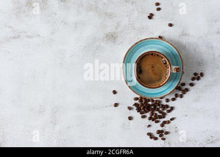 Kaffeetasse und Bohnen auf grauem Hintergrund Draufsicht mit Kopierplatz. Stockfoto