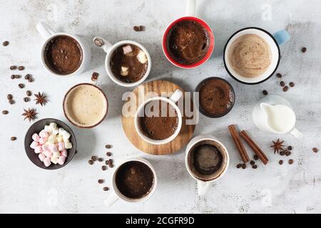 Viele Tassen verschiedener Kaffeegetränke auf grauem Hintergrund Draufsicht. Vielfalt an Kaffee Konzept. Stockfoto