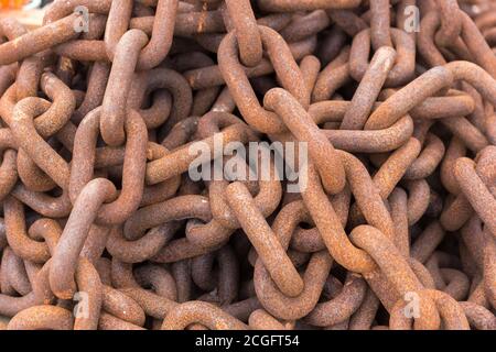 Eine lange rostige Kette, die in einen Haufen gehäuft wurde Stockfoto