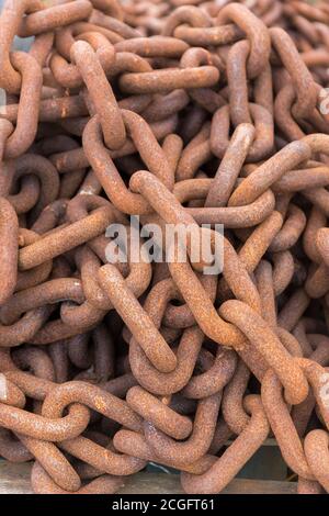 Eine lange rostige Kette, die in einen Haufen gehäuft wurde Stockfoto