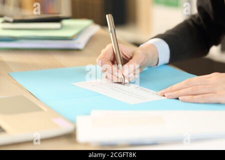 Nahaufnahme der selbstständigen Frau Hände Unterzeichnung Bankscheck Sitzen im Homeoffice Stockfoto