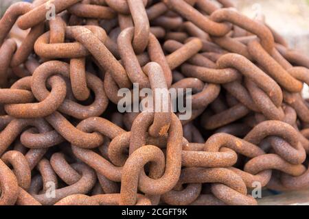 Eine lange rostige Kette, die in einen Haufen gehäuft wurde Stockfoto