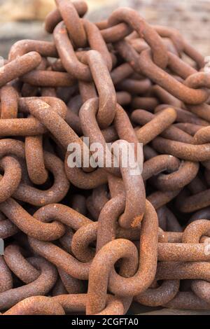 Eine lange rostige Kette, die in einen Haufen gehäuft wurde Stockfoto