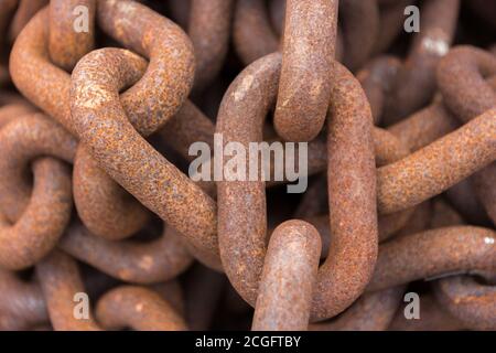 Eine lange rostige Kette, die in einen Haufen gehäuft wurde Stockfoto