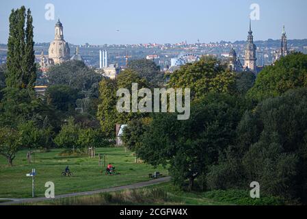 Dresden, Deutschland. September 2020. Am Morgen radeln Radfahrer über die Elbwiesen, im Hintergrund sieht man die Frauenkirche (l-r), die Kuppel der Akademie der Künste, das Ständehaus, den Hausmannsturm und die Hofkirche in der Altstadt. Quelle: Robert Michael/dpa-Zentralbild/ZB/dpa/Alamy Live News Stockfoto