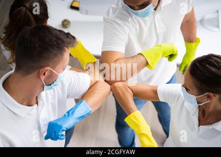 Professionelle Büroreinigung Hausmeister Team Spirit Und Huddle Mit Gesicht Masken Stockfoto