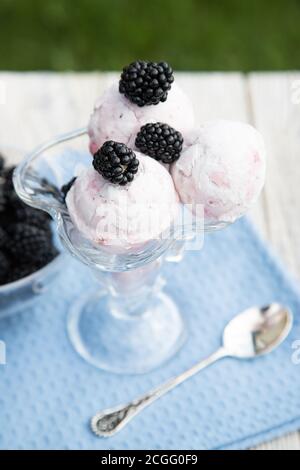 Eine Schüssel mit Eis und Brombeeren sitzt auf einer blauen Serviette. Nahaufnahme. Stockfoto