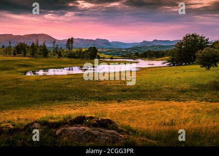 Sonnenuntergang über den Langdale Pikes und Wise Een Tarn im English Lake District. In der Nähe von Hill Top das Zuhause von Beatrix Potter Stockfoto