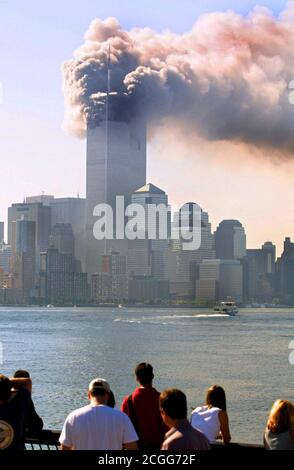 Blick von Staten Island auf das brennende World Trade Center in New York nach dem Anschlag am 11. September 2001. Heute Morgen rasten in schneller Folge zwei Flugzeuge in die Türme des World Trade Centers. Neben den Insassen der Maschinen wurden in den beiden Wolkenkratzern bei den schweren Explosionen zahlreiche Menschen getötet. Offenbar handelt es sich um einen gezielten Angriff terroristischer Selbstmordattentäter. Die oberen Teile des Wolkenkratzers gingen in Flammen auf. Teile der Trümmer und Gebäude der 411 Meter hohen Zwillingstürme flogen auf die Straße. Mit einer völlig freien Sicht hatten die Maschinen in die raste Stockfoto