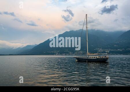 Segelboot in der Mitte des Lago Maggiore in der Abenddämmerung Die Grenze zwischen Italien und der Schweiz Stockfoto