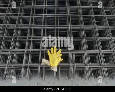 Gelbe Handschuhe stehen auf eisernem Hintergrund Stockfoto