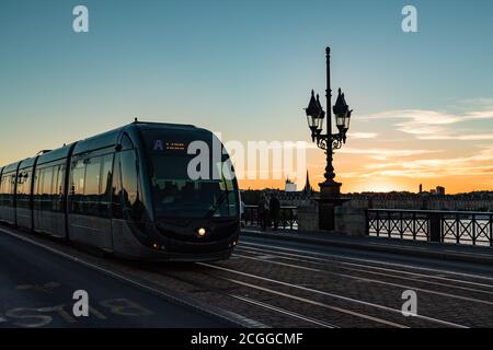 Bordeaux, Frankreich - 25. September, 2018: Tram über Pont de Pierre Brücke in der Stadt Bordeaux bei Sonnenuntergang. Stockfoto