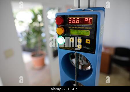 Bukarest, Rumänien - 10. September 2020: Details mit einem menschlichen Körperthermometer am Eingang einer öffentlichen Schule während des Covid-19-Ausbruchs. Stockfoto