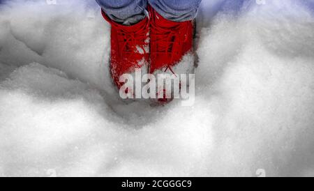 Rote Stiefel auf dem Boden von Schnee bedeckt Stockfoto