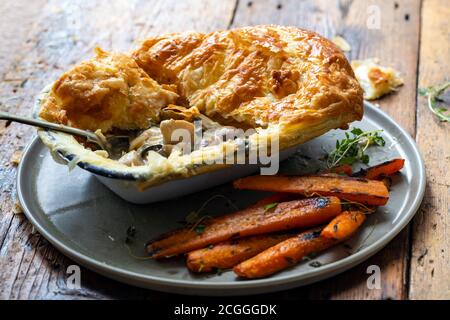 Hühnchen- und Pilzkuchen mit gebratenen Karotten Stockfoto