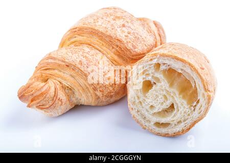 Geschnittene und ganze Croissants isoliert auf weißem Hintergrund. Nahaufnahme. Stockfoto