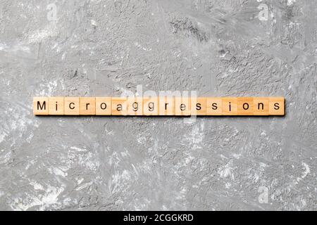 Microaggressions Wort auf Holzblock geschrieben. Microaggressions Text auf Zementtisch für Ihr Design, Konzept. Stockfoto